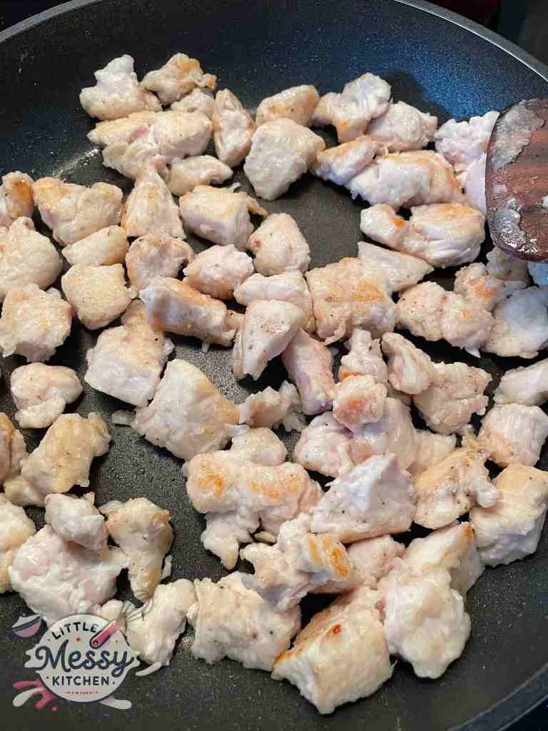 Chicken cooking in skillet.