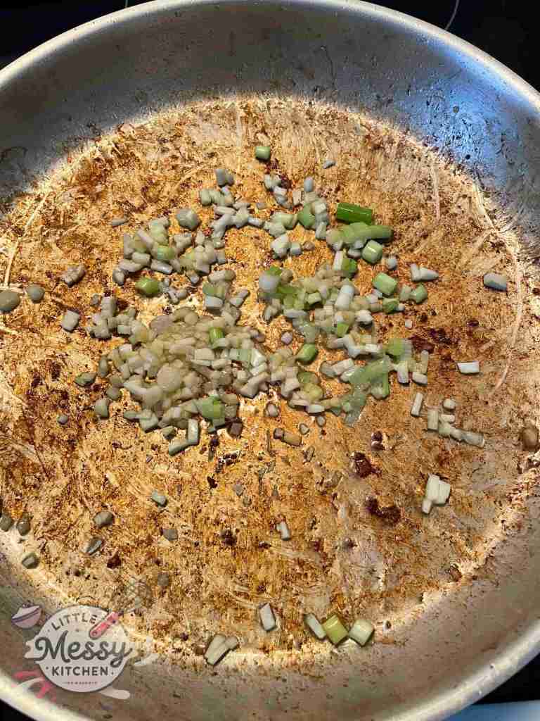 Green onions. garlic and ginger cooking in a frying pan.