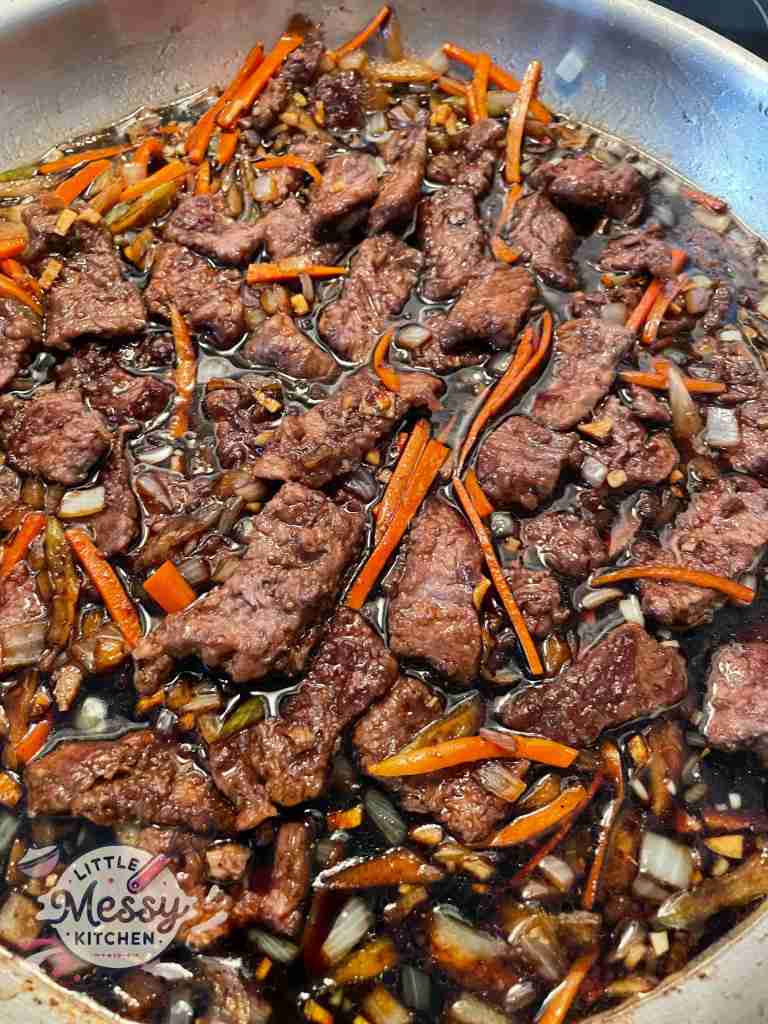 Beef added to the frying pan.