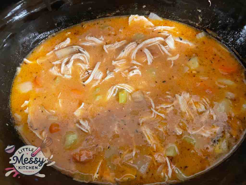 Cooked vegetables, broth chicken and spices in slow cooker.