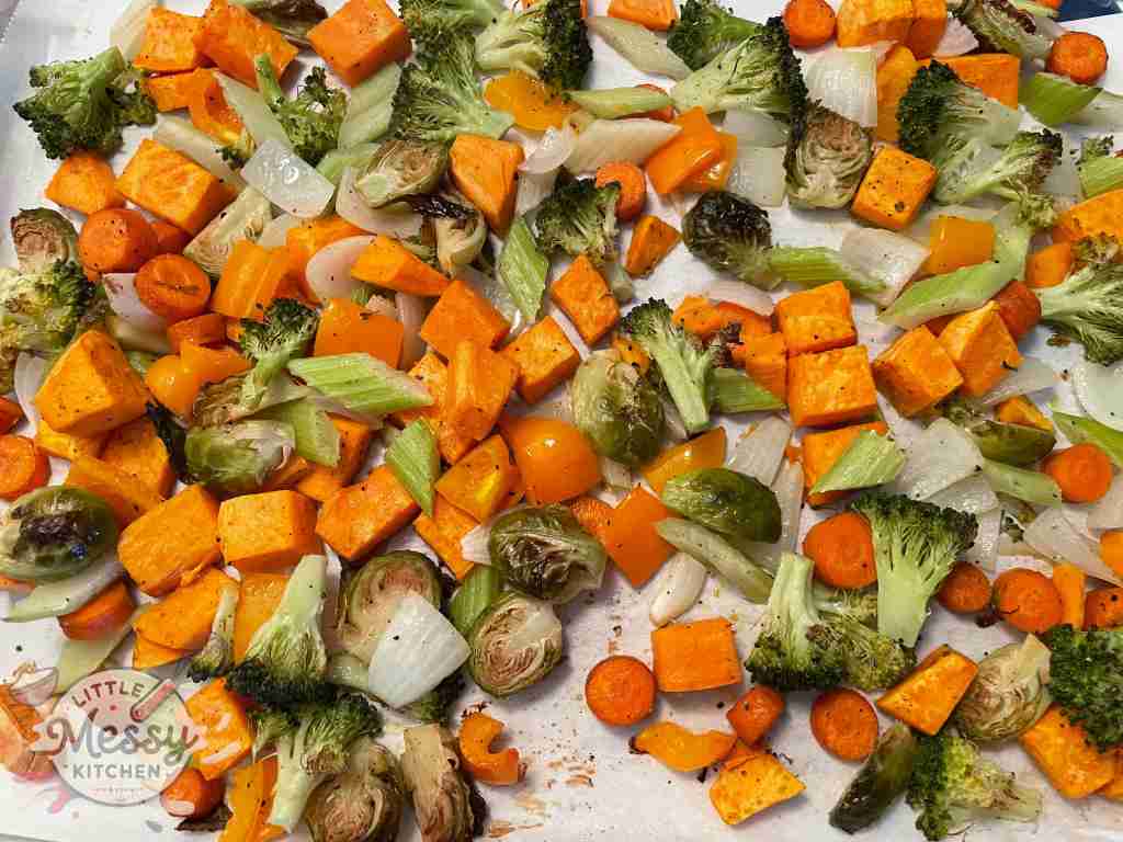 Celery, bell pepper, broccoli, and onion added to the baking sheet
