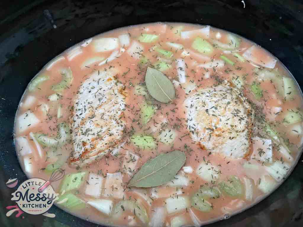 Vegetables, broth chicken and spices in slow cooker.
