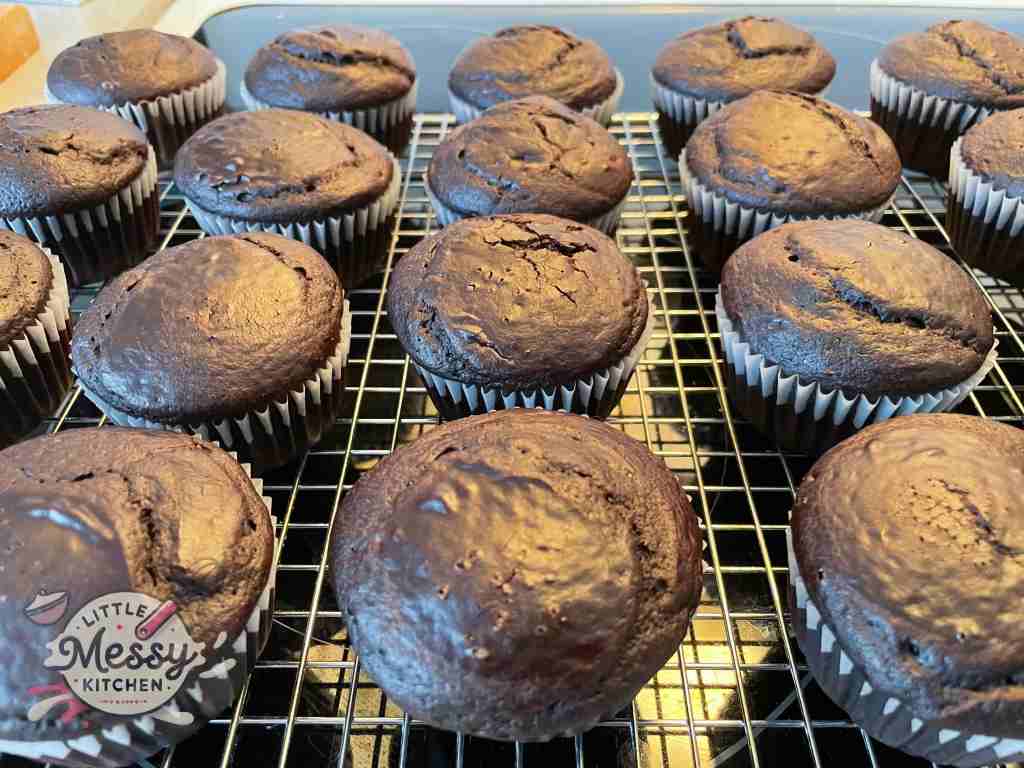 Cooked cupcakes on a cooling rack.