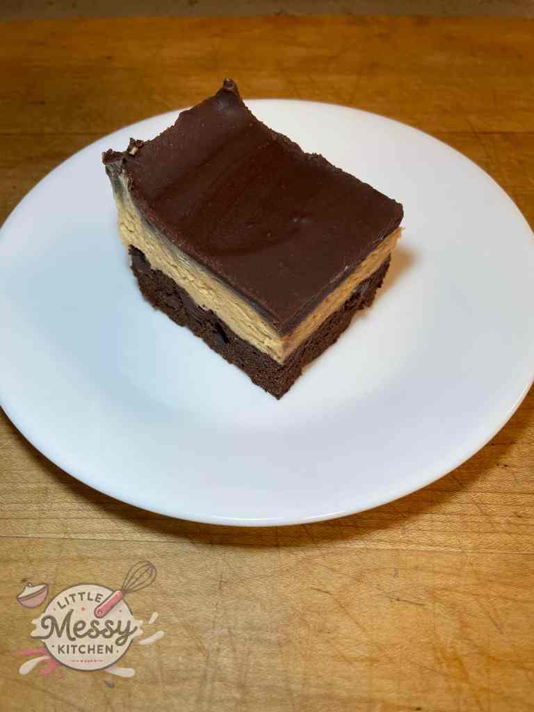 Serving of Triple Layer Buckeye Bars on a white plate.