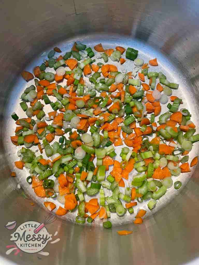 Diced vegetable sauteing in a stockpot.