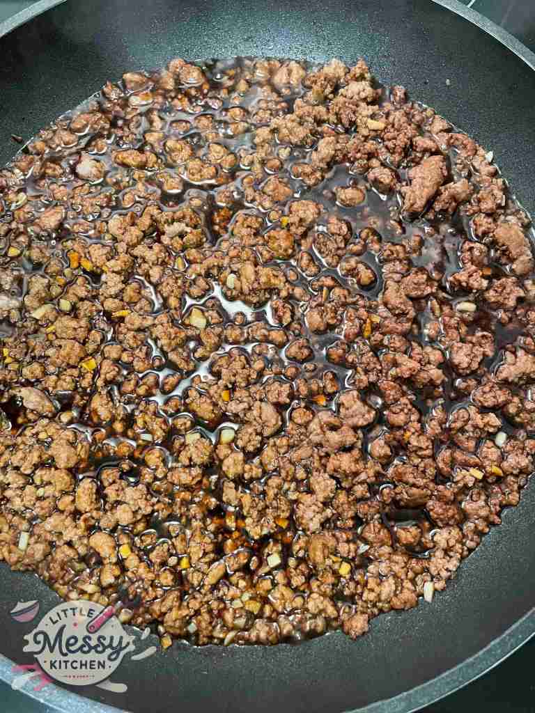 Sauce ingredients added to the ground beef.