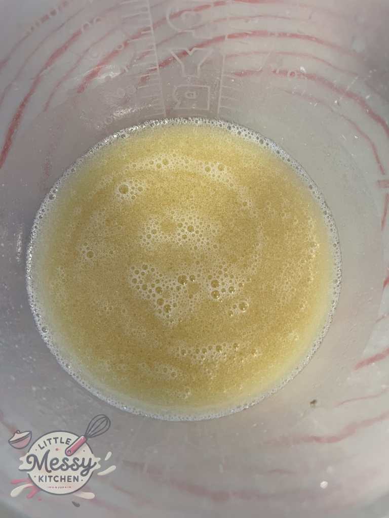 Water, dry yeast, oil and sugar in a mixing bowl.
