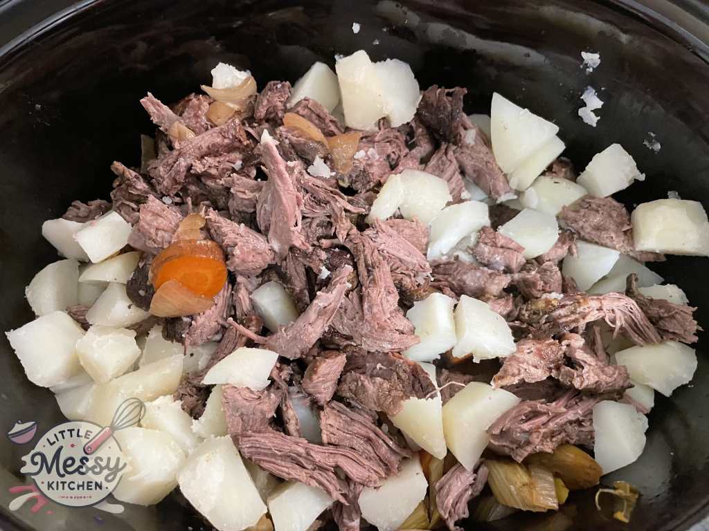 Beef sliced and potatoes added to the slow cooker.
