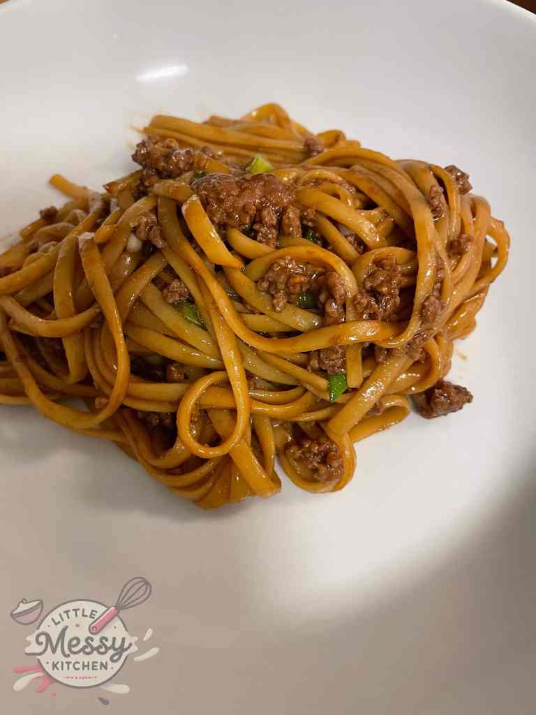 Serving of Mongolian-style Beef Noodle in a white bowl.