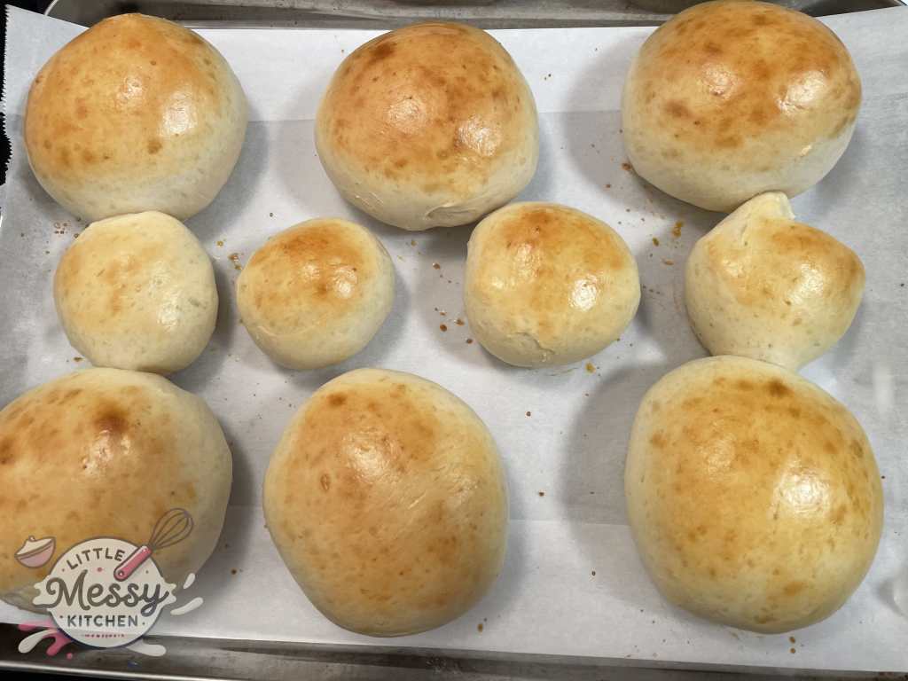 Burger buns out of the oven on a baking sheet.