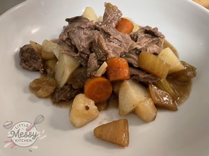 Serving of pot roast in a white bowl.