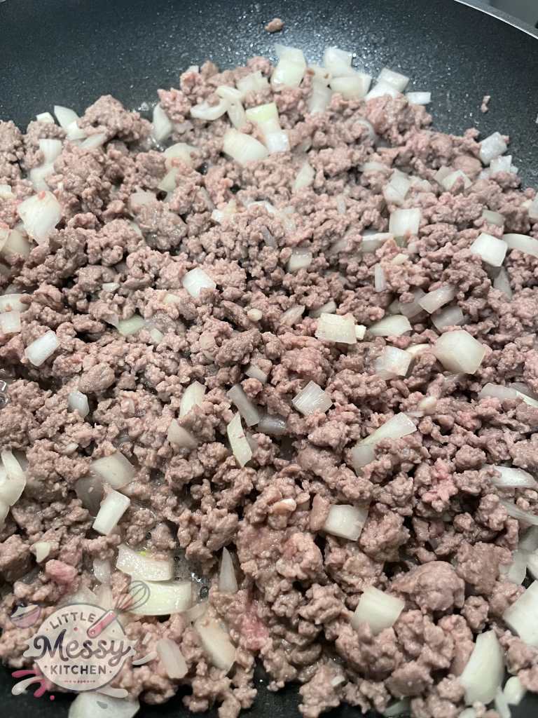 Ground beef and onions cooking in skillet.