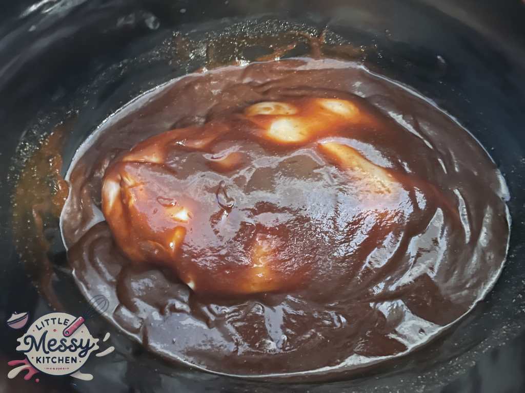 Sauce mixture poured over chicken breasts in slow cooker
